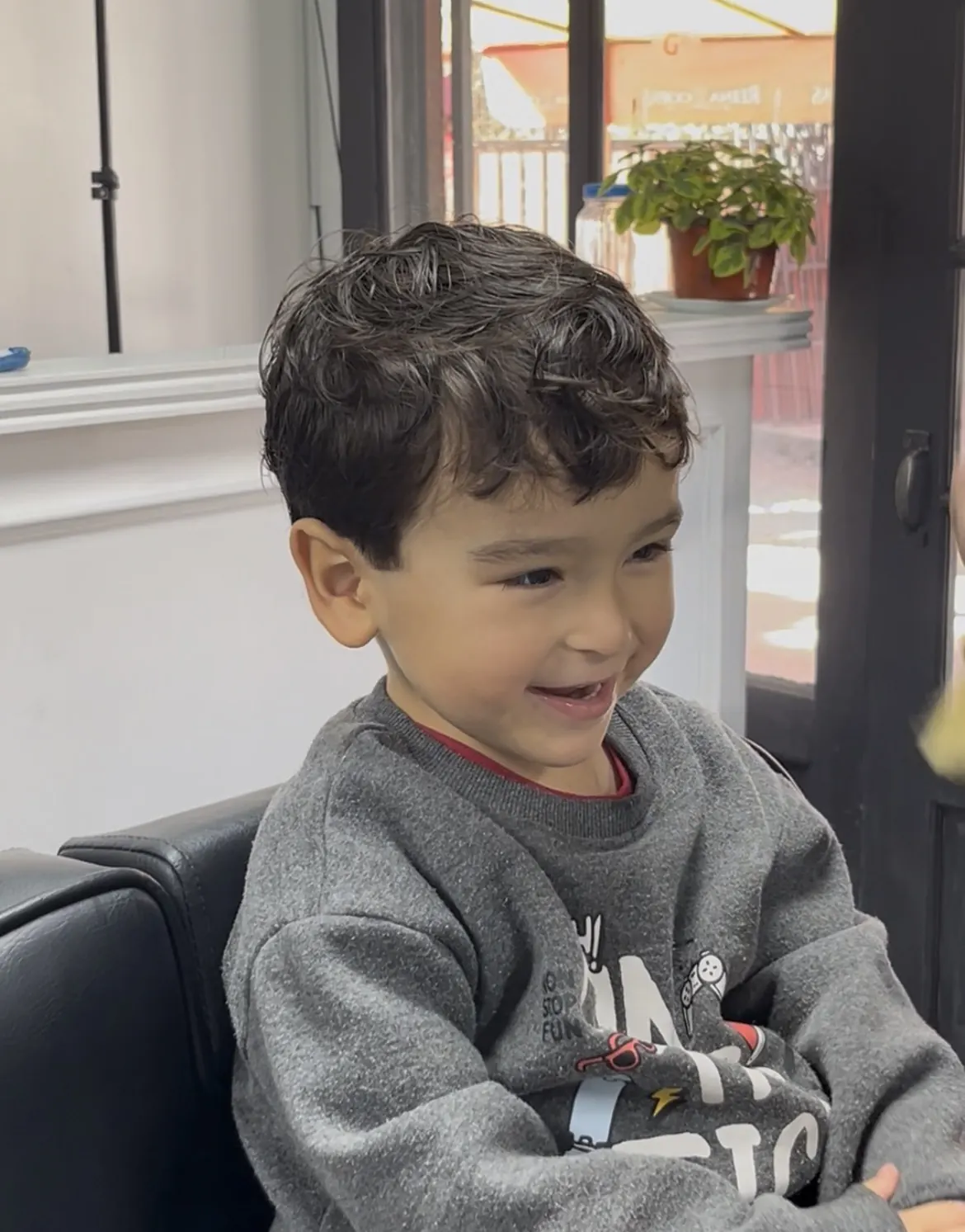 Niño sonriendo después de su corte de cabello