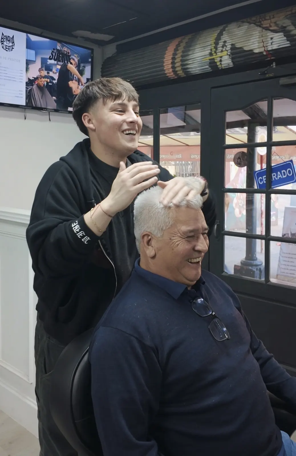 Barbero y cliente riendo, corte de caballero mayor